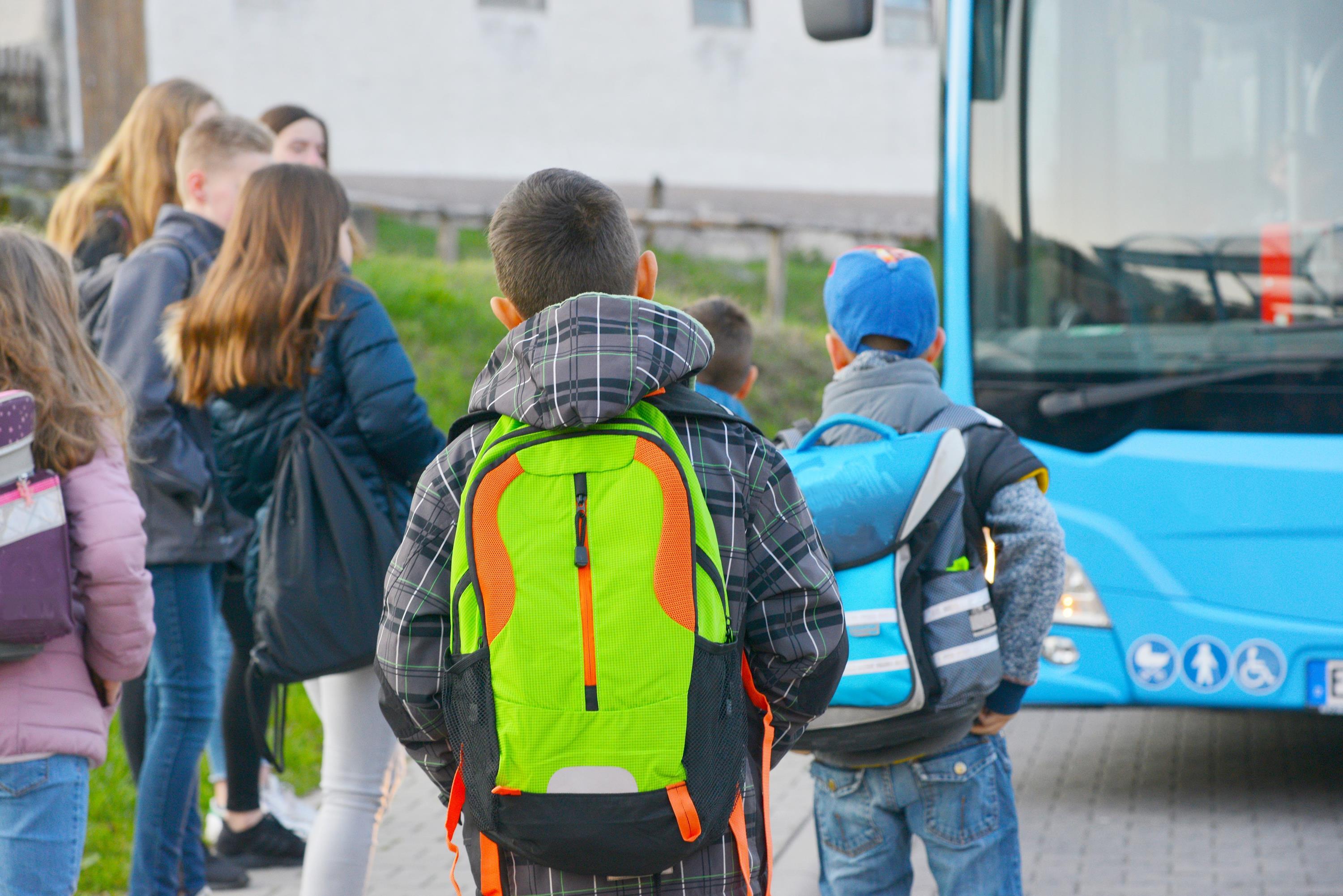 Schüler stehen vor dem Bus.