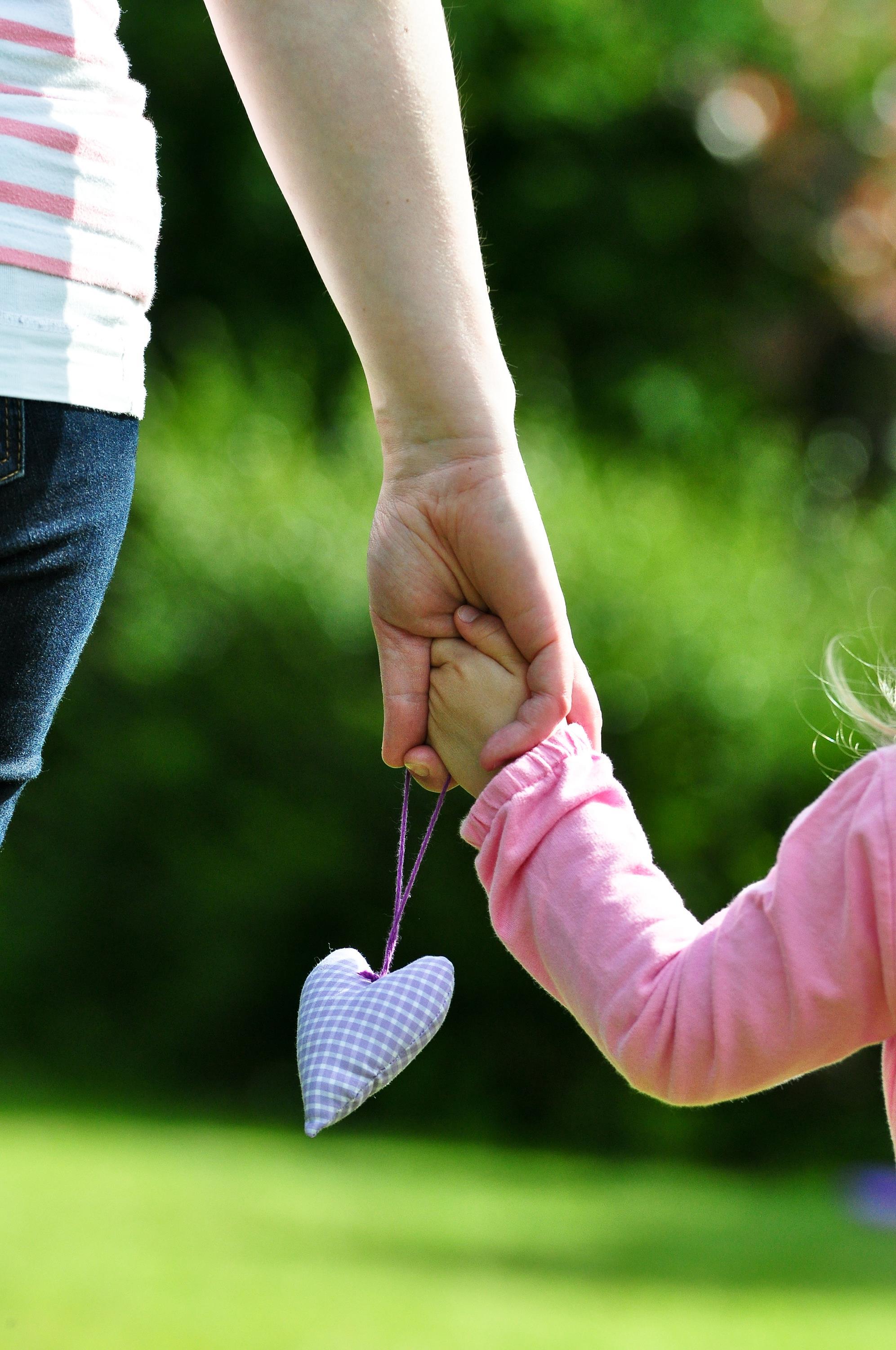 Mutter und Kind halten sich an der Hand