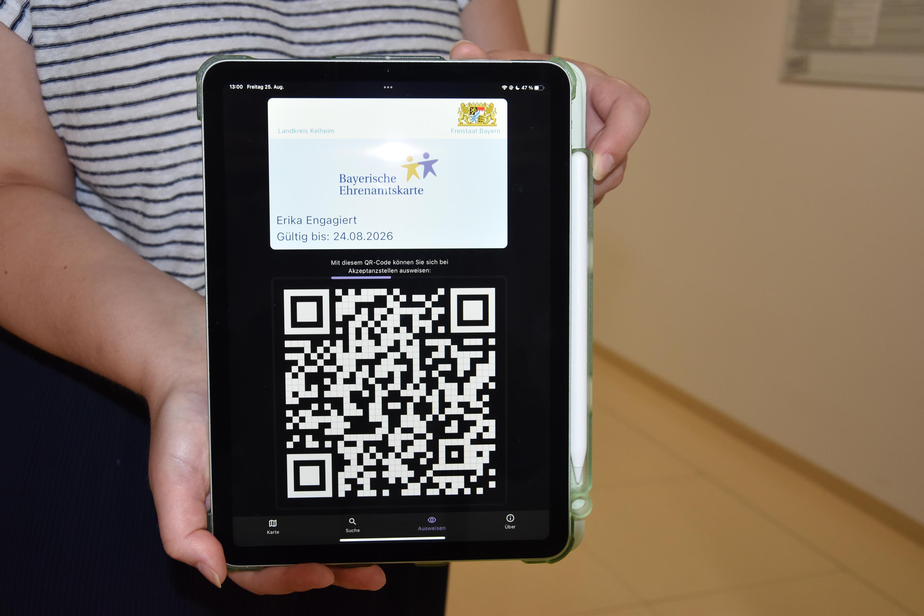 Die hellblaue Ehrenamtskarte über einem QR-Code auf einem Ipad