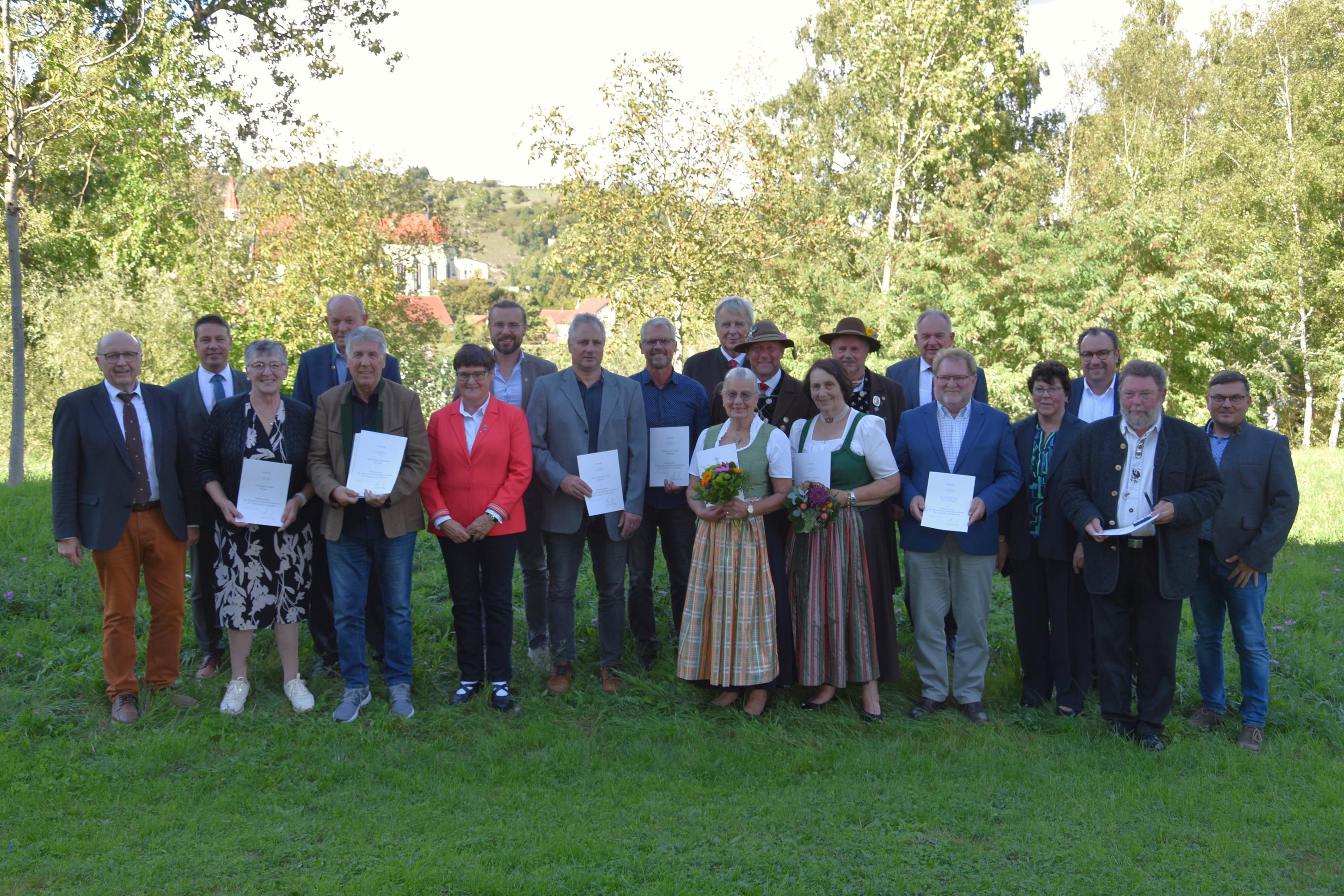 Gruppenfoto Aushändigung Ehrenzeichen Landrat Neumeyer händigt acht Frauen und Männern ein Ehrenzeichen aus.