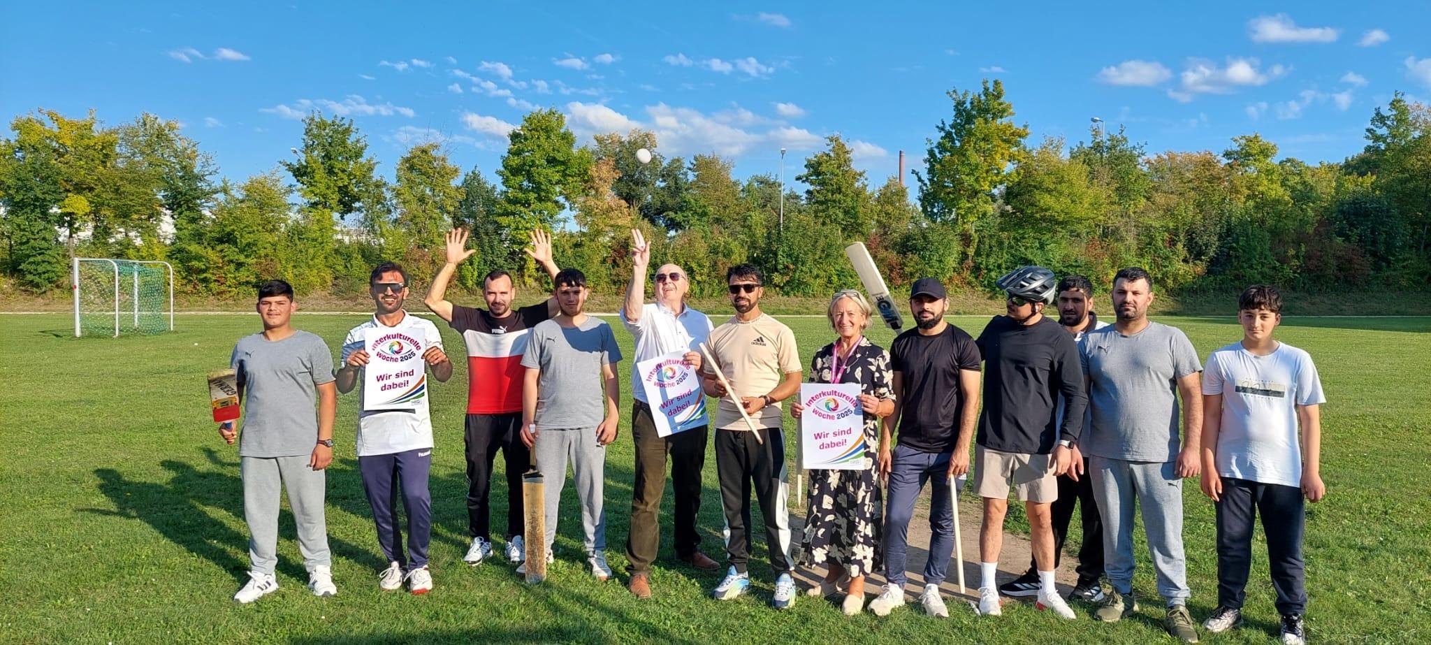Landrat Martin Neumeyer mit zehn jungen Männern auf dem Cricket-Feld.