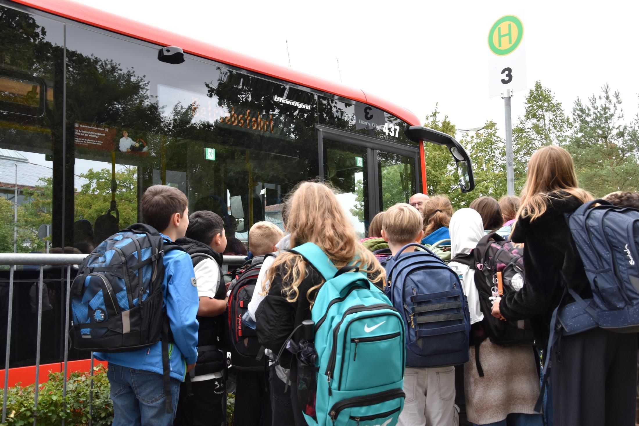 Schüler stehen vor einem Bus an