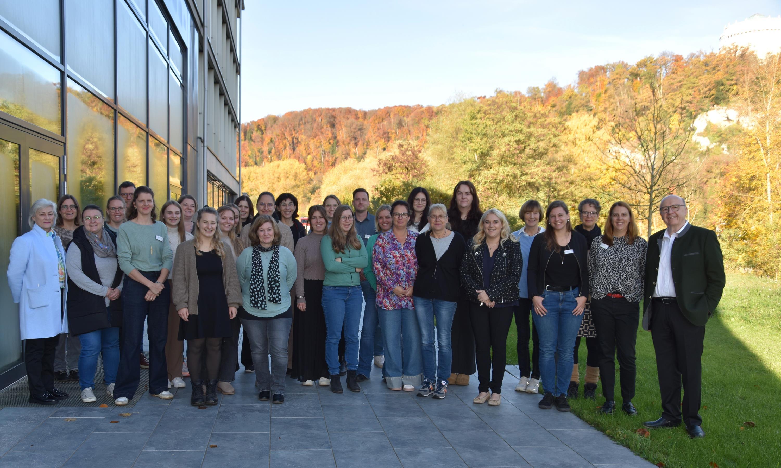 Eine große Gruppe von Menschen steht auf der Terrasse des Landratsamts