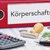 Zu sehen sind ein Taschenrechner, Geld, ein Stempel und ein Ordner