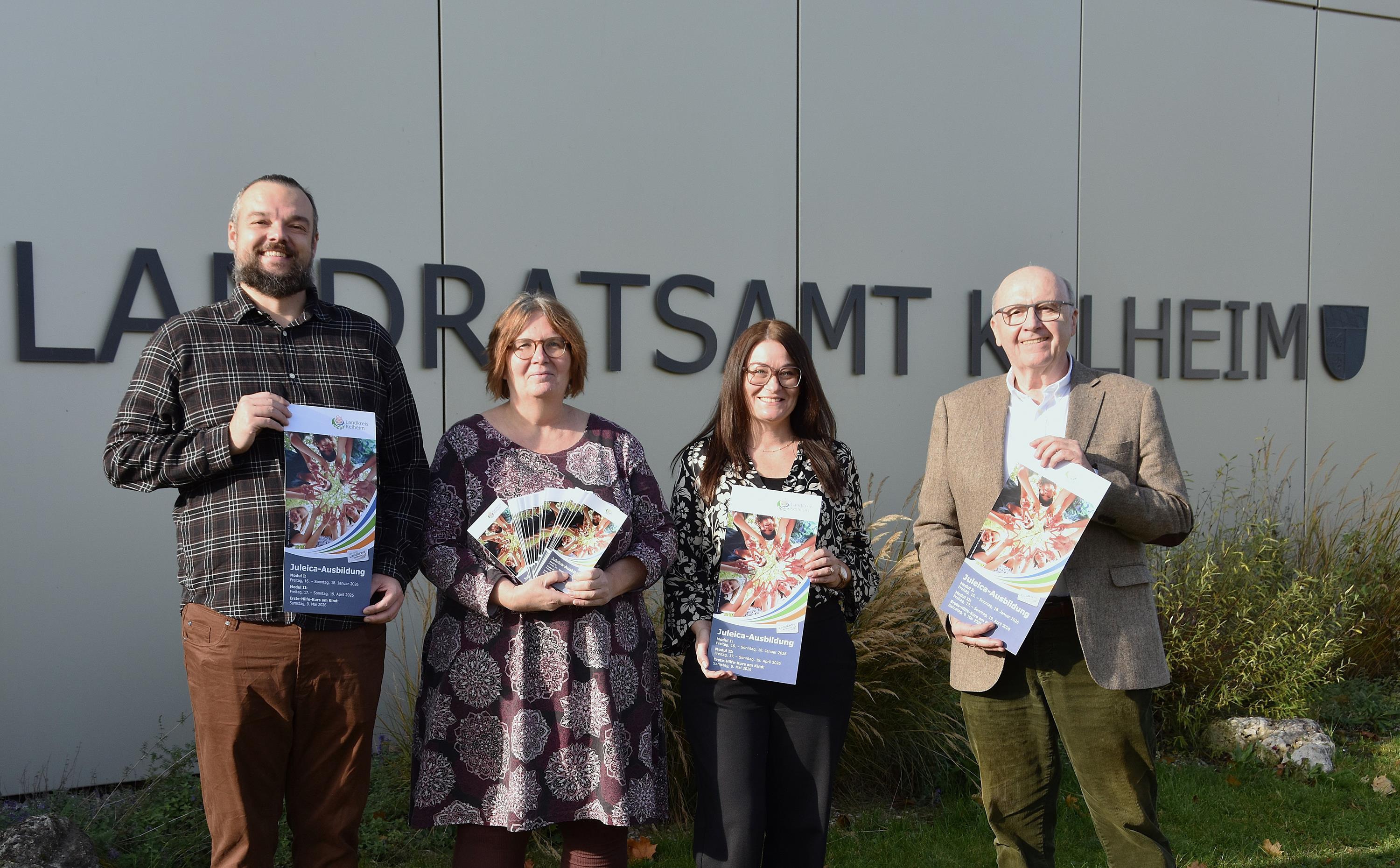 Zwei Männer und zwei Frauen präsentieren Flyer vor dem Landratsamt
