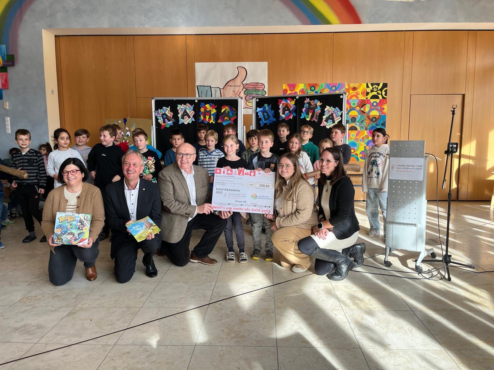 Eine Grundschulklasse präsentiert einen Scheck.