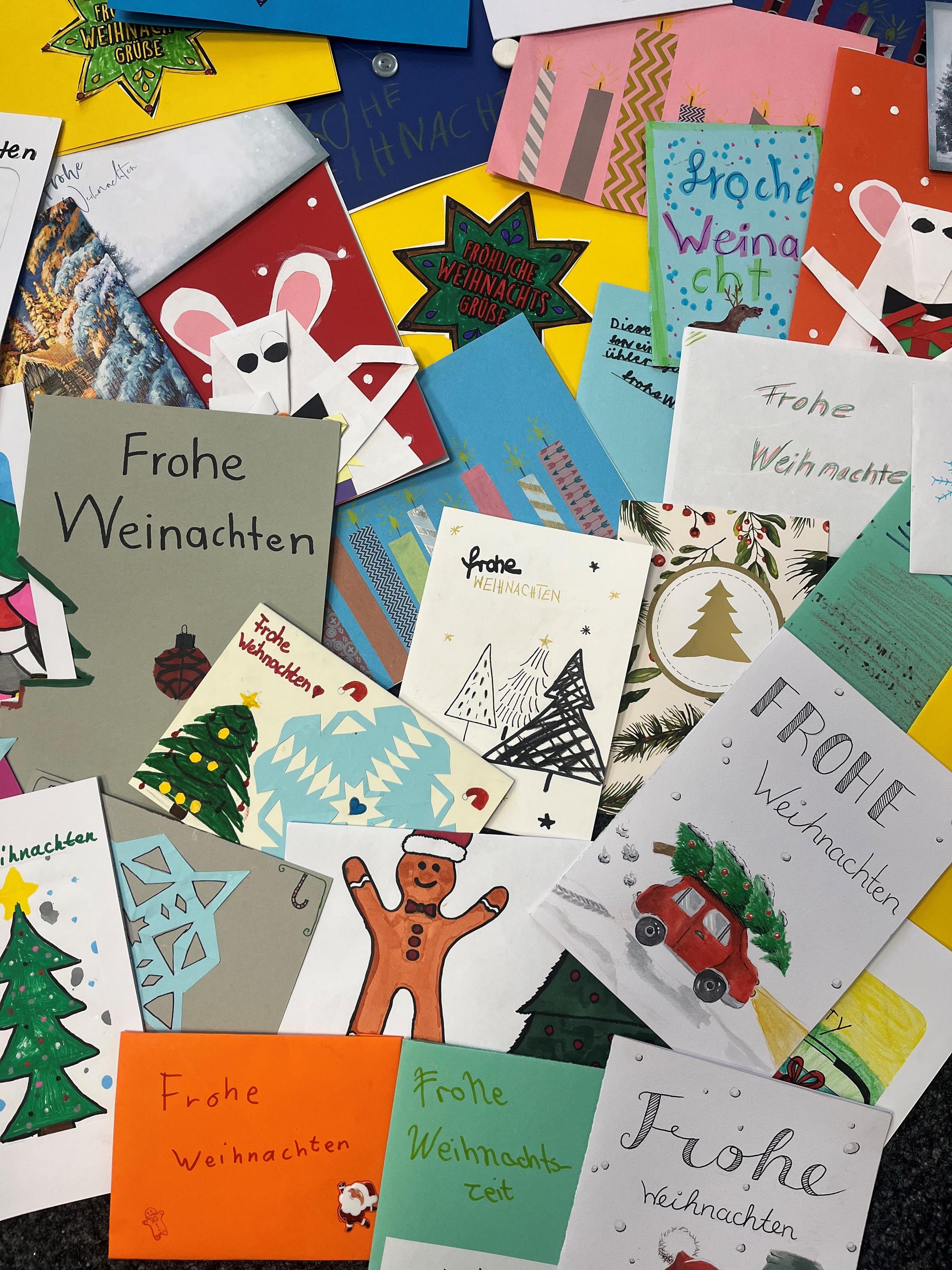 Weihnachtspostkaren und Briefe liegen quer übereinander verstreut.