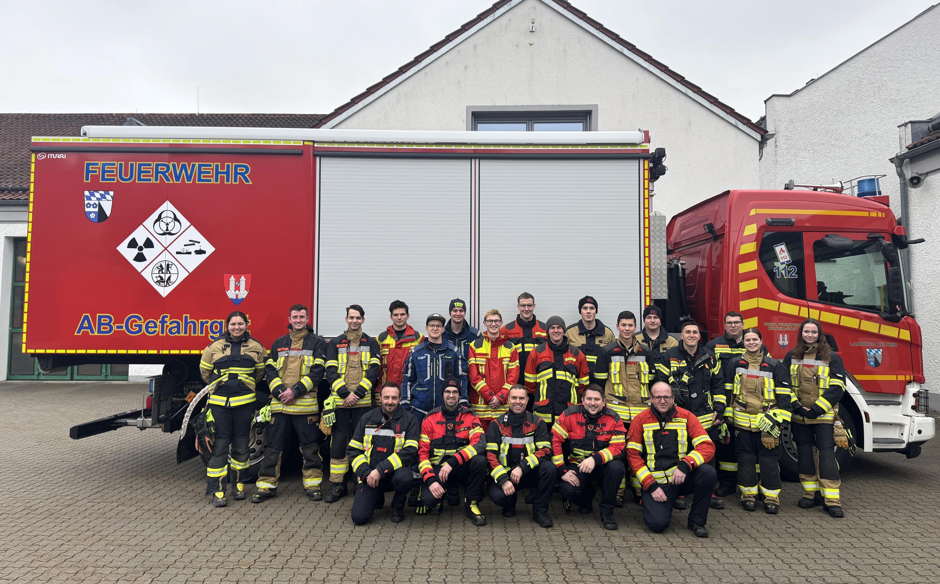 Feuerwehrmänner und -frauen vor einem Feuerwehrauto.