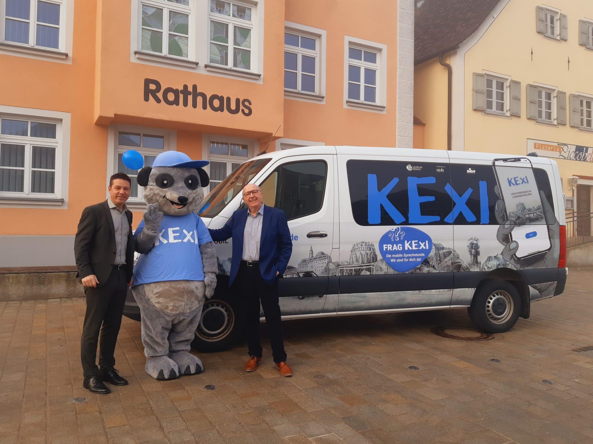 Bürgermeister, Erdmännchen-Maskottchen und Landrat vor Kleinbus