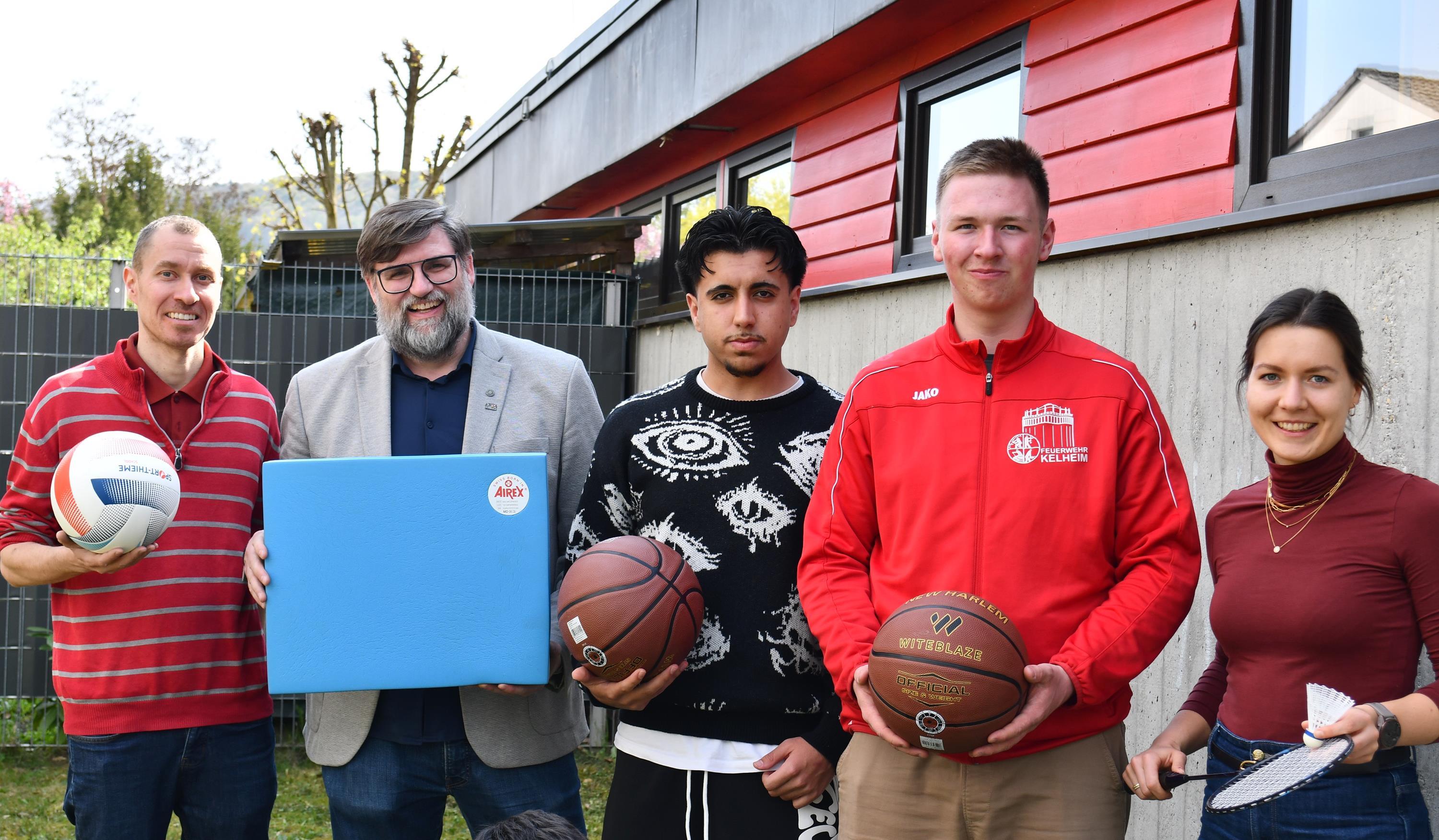 Zwei Männer, zwei Jugendliche und eine Frau mit Sportartikeln