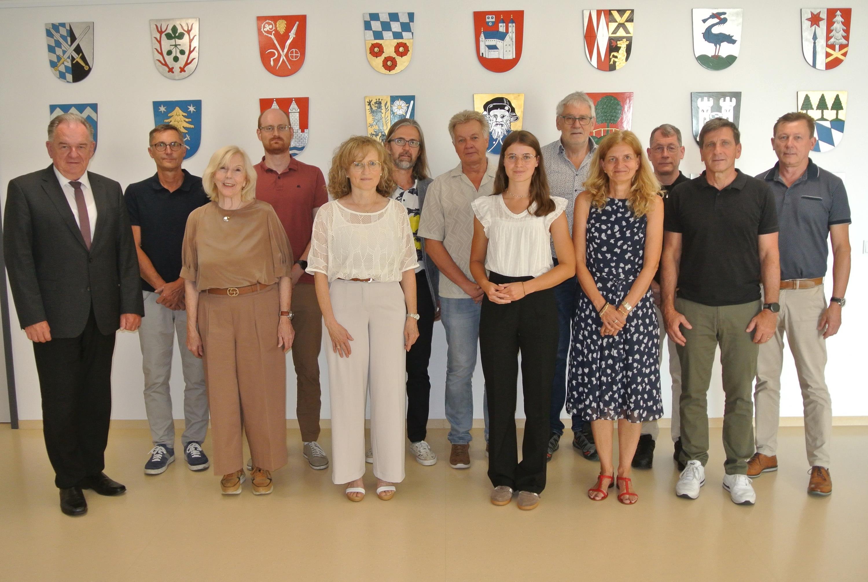 Die Mitglieder des Gutachterausschusses stehen vor einer Wand
