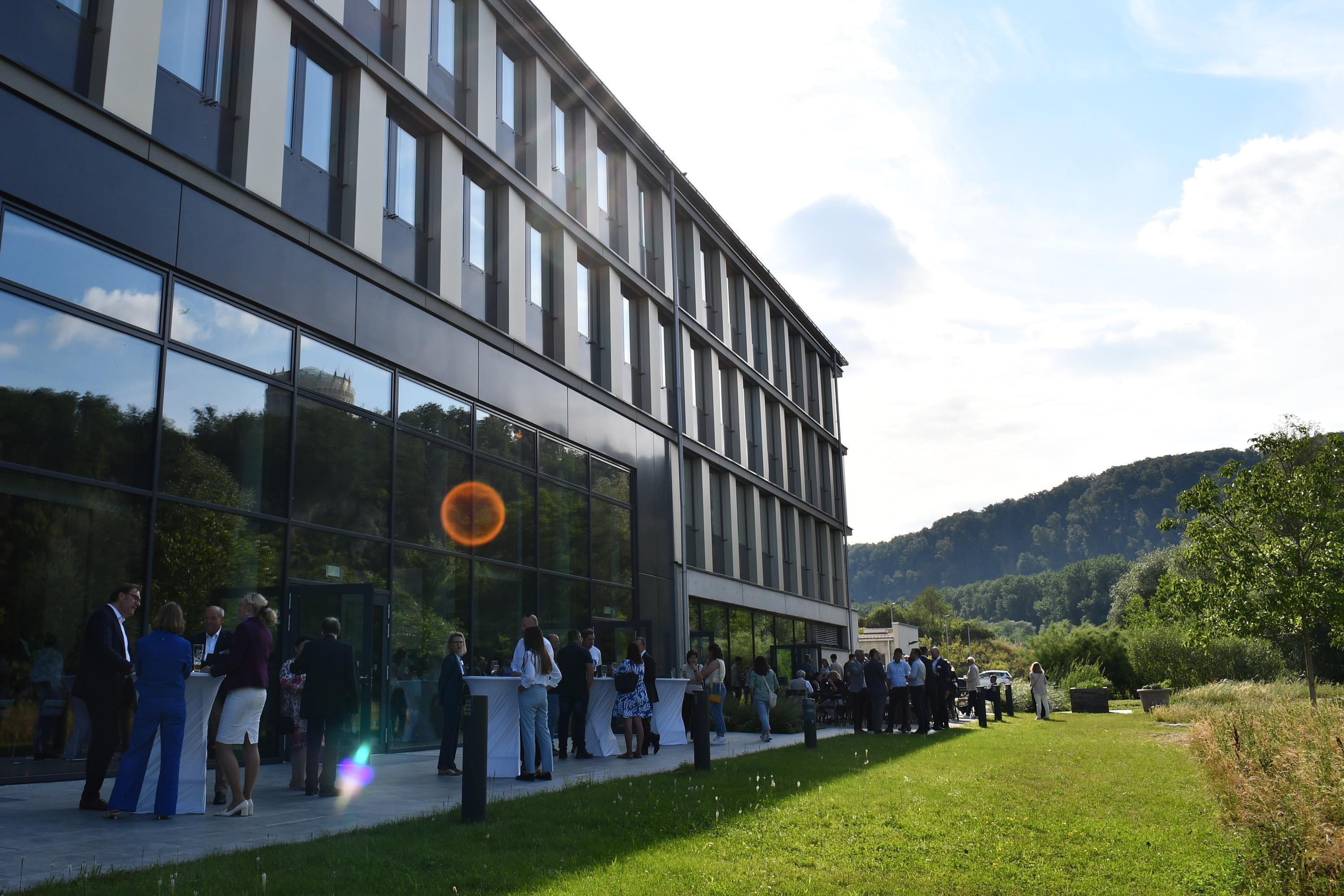 Menschen stehen vor einem Gebäude und unterhalten sich