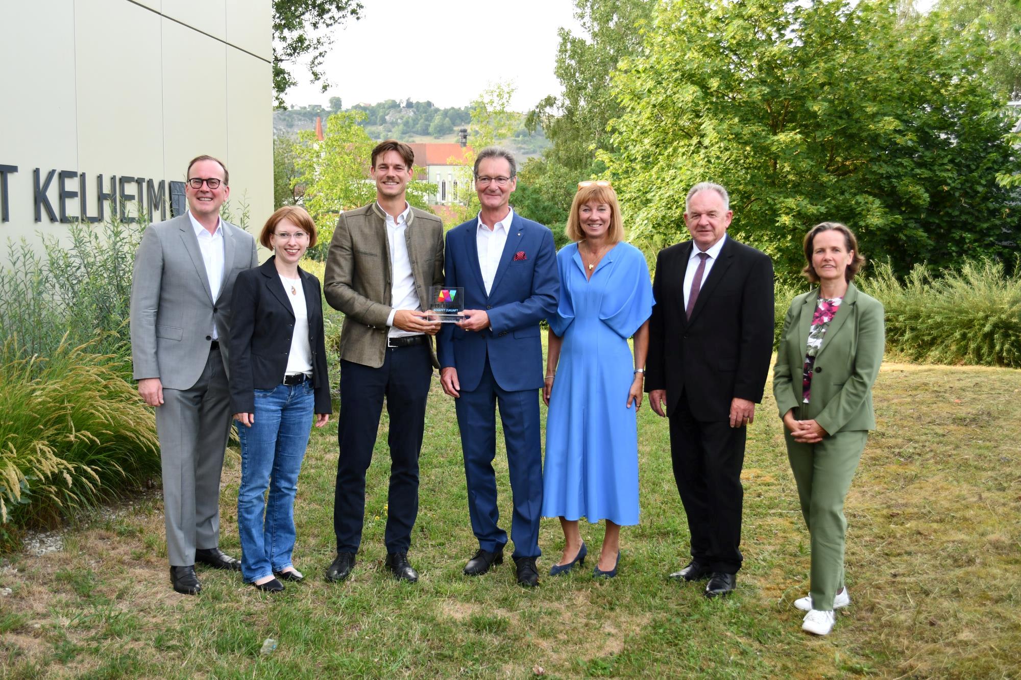 Menschen stehen nebeneinander und präsentieren ihre Auszeichnung
