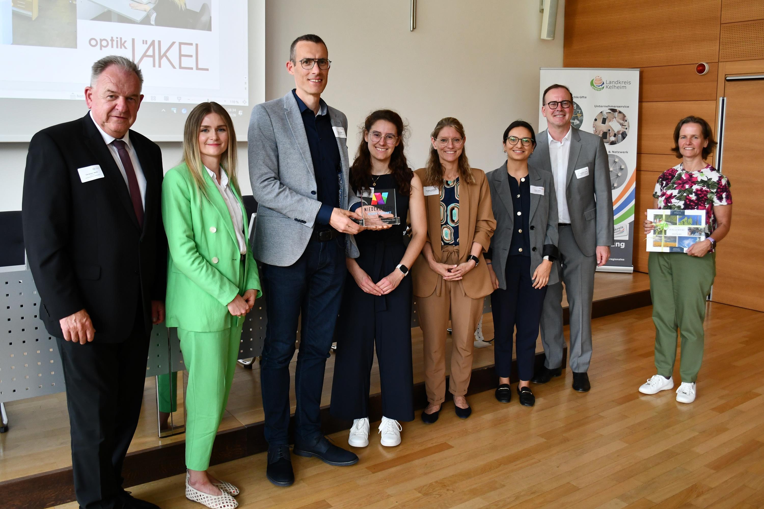 Menschen stehen nebeneinander und präsentieren ihre Auszeichnung