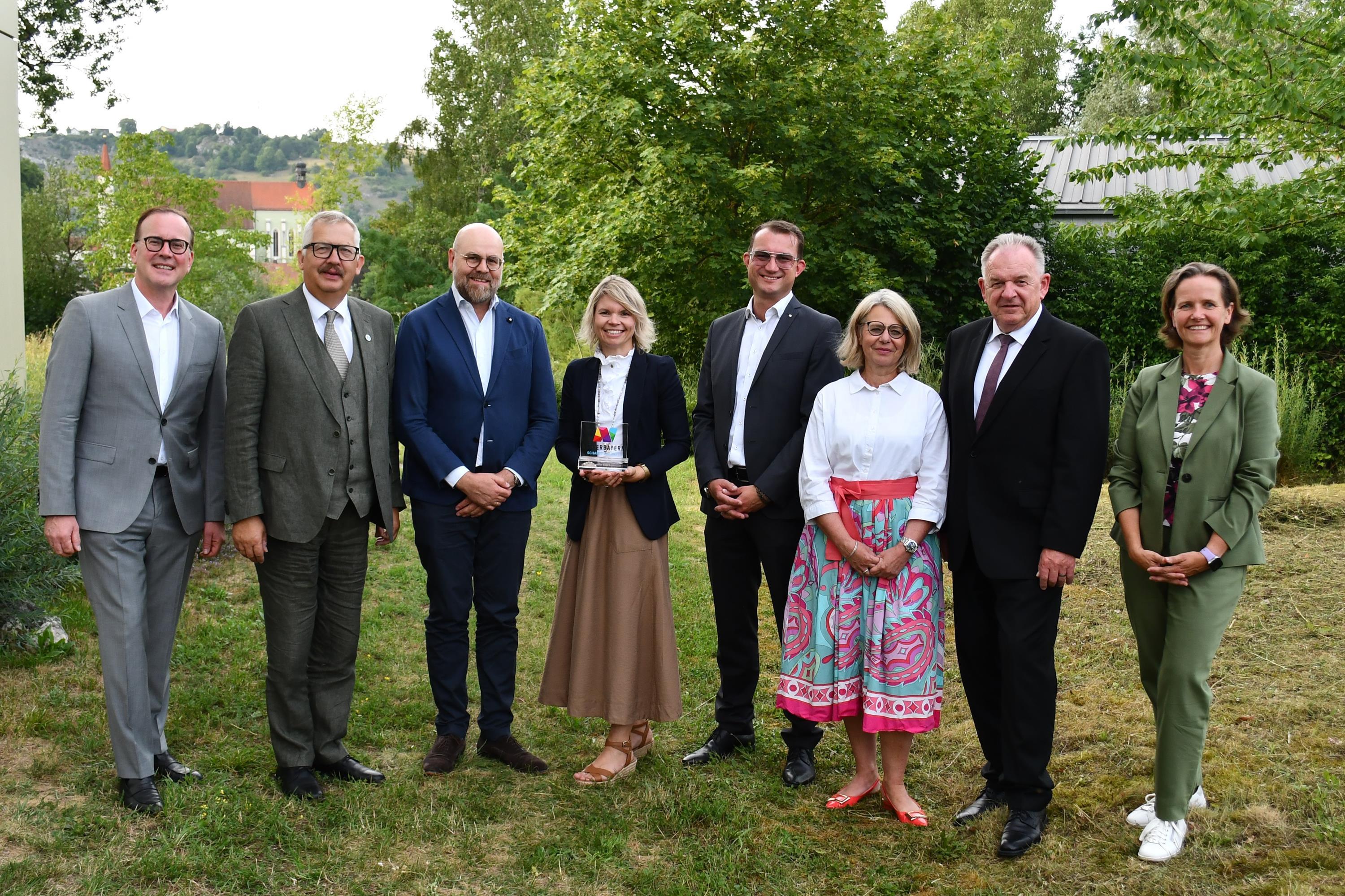 Menschen stehen nebeneinander und präsentieren ihre Auszeichnung