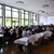 Menschen sitzen in einem großen Saal und hören einer Rede zu