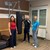 Zwei Frauen und ein Mann mit Boxhandschuhen flankieren einen Boxsack