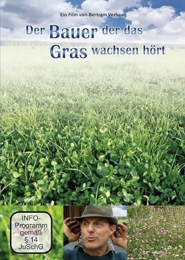 Ein Bauer vor einer grünen Wiese 