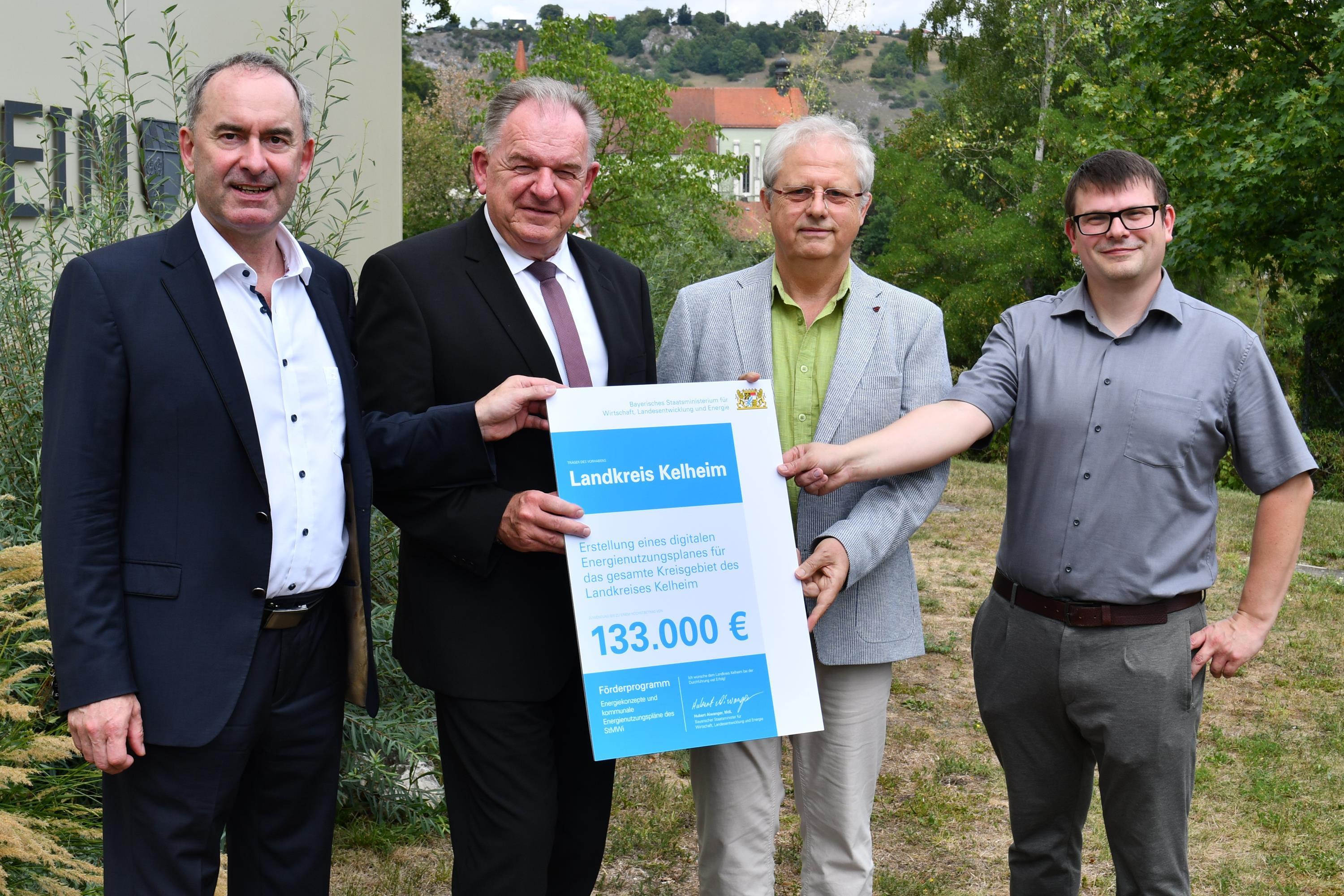 4 Männer neben Landratsamt halten Papier mit Fördersumme