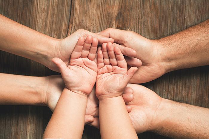 Drei Handpaare übereinander - Eltern und Kind