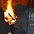 Im Hintergrund Feuer, im Vordergrund vermummte Feuerwehrmänner