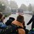 Schüler stehen am Fahrbahnrand und warten auf einen ankommenden Bus